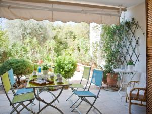 a table and chairs on a patio with a table and chairs at Comfortable garden Apt near Vouliagmeni beach in Athens