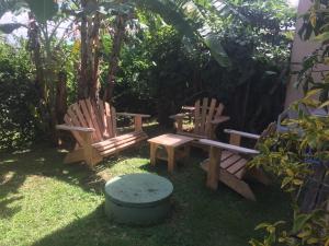 two wooden chairs and a table in a yard at CoCoKreyol - " ARUBA" in Les Trois-Îlets
