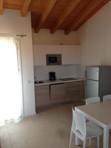 a kitchen with white appliances and a table and chairs at Villaggio Margherita in Caorle