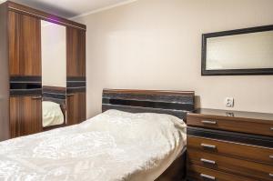マグニトゴルスクにあるLenina 116のベッドルーム1室(ベッド1台、ドレッサー、鏡付)