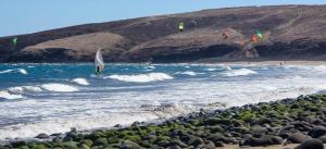 a person on a surfboard in the water at the beach at Vacacional Tegueste 2ºB in Vecindario