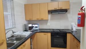 uma cozinha com um lavatório e um fogão forno superior em Brookes Hill suites no 18 em Port Elizabeth