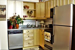 a kitchen with a stainless steel refrigerator and wooden cabinets at Beautifully decorated, 3 bedroom 2 bedroom condo is moments away from the Base Lodges Whiffletree D2 in Killington