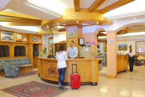 Ein Mann und eine Frau stehen an einem Tresen in einem Salon. in der Unterkunft Hotel Sant'Ilario in Rovereto