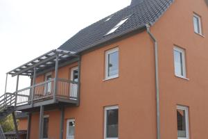a house with a balcony and a roof at 3 Zimmer Ferienwohnung - Woltorf in Peine