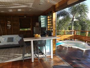 a kitchen with a table and chairs on a deck at BUNGA-LODGE (bungalow 4* avec piscine privée) in Douville