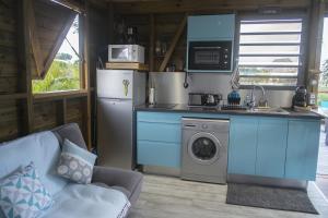 a kitchen with a refrigerator and a washing machine at BUNGA-LODGE (bungalow 4* avec piscine privée) in Douville