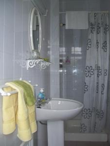 a white bathroom with a sink and a mirror at Meadowfield in Ballyvaughan