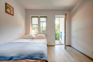 a bedroom with a bed and an open door at Apartamenty Poddąbek- basen kryty, sauna, animacje dla dzieci , małpi gaj, baseny na dachu in Poddąbie +114 photos