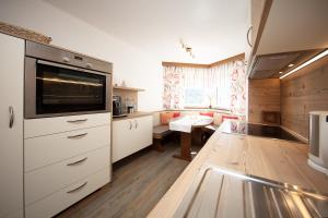 a kitchen with white cabinets and a large appliance at Appartement Harmonie in Sölden
