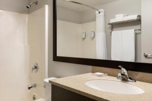 a bathroom with a sink and a mirror at Travelodge Suites by Wyndham New Glasgow in New Glasgow