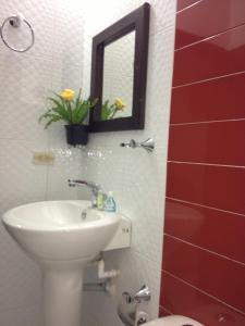 un baño con lavabo y espejo en Hotel Casa Pablo, en Neiva