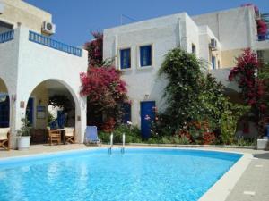 a large blue swimming pool in front of a building at Creta Sun Hotel Studios in Agia Pelagia
