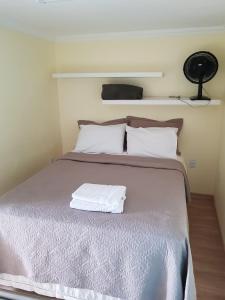 Una cama con dos almohadas blancas encima. en Hostel Trem de Minas, en Belo Horizonte