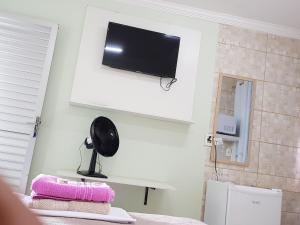 a room with a flat screen tv on a wall at Hostel Trem de Minas in Belo Horizonte