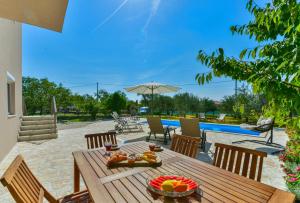 a wooden table with fruit on top of a patio at Holiday Home M&M in Benkovac