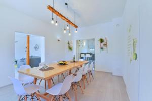 a dining room with a wooden table and white chairs at Holiday Home M&M in Benkovac
