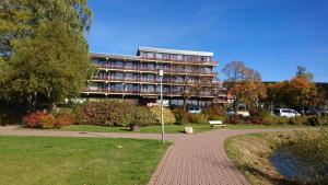 un grand bâtiment avec un chemin devant lui dans l'établissement Apartment mit Seeblick Vier Jahreszeiten, à Hahnenklee