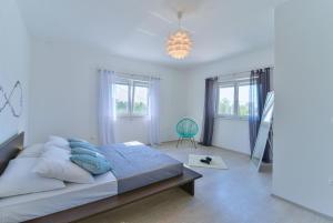a bedroom with a bed and a chair and windows at Holiday Home M&M in Benkovac +35 photos