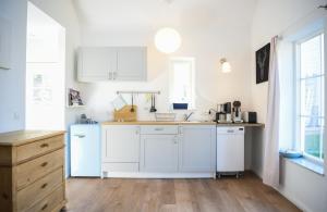 a kitchen with white cabinets and a wooden floor at Haus Madita in Breitnau
