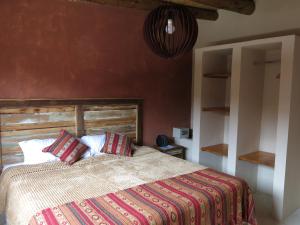 a bedroom with a bed with a wooden headboard at Casatilcara Cabañas in Tilcara