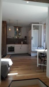 uma cozinha com armários brancos e uma mesa num quarto em L'appartement d'Anna em Annecy