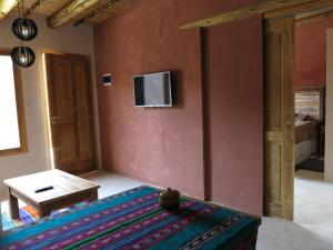 a living room with a tv on a wall at Casatilcara Cabañas in Tilcara