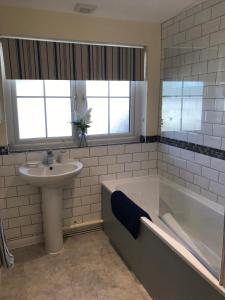 une salle de bain avec un lavabo et une baignoire et un lavabo dans l'établissement Windmill Cottage, à Worthing 29 autres photos