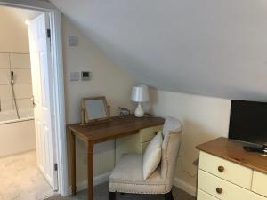 Habitación con escritorio, espejo y silla. en Windmill Cottage en Worthing