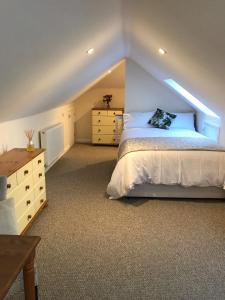a bedroom with a bed and a dresser in a attic at Windmill Cottage in Worthing