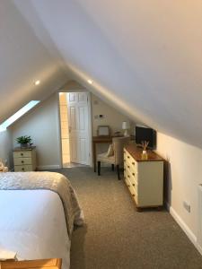 une chambre avec un lit et un bureau avec une télévision dans l'établissement Windmill Cottage, à Worthing