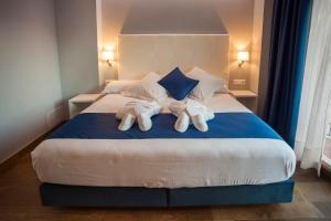 a bedroom with a large bed with towels on it at Hotel Boutique Barra Alta (Adults Only) in Peñíscola