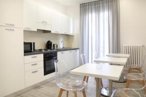 une cuisine avec des placards blancs et une table et des chaises blanches dans l'établissement Primo a destra, à Campobasso