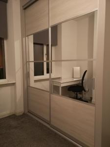 a room with a glass partition with a desk at Sleep Well Apartment in Glasgow
