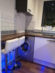a kitchen with a washing machine and a counter at Sleep Well Apartment in Glasgow