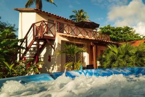 a house behind a pool of water in front of a house at 21 Palms in Las Galeras