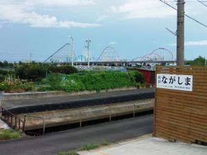 a sign on the side of a road with a roller coaster at Minpaku Nagashima room4 / Vacation STAY 1033 in Kuwana +1 photo