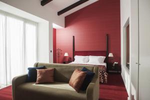 - un salon avec un canapé en face d'un lit dans l'établissement Real Abadia, Congress & Spa Hotel, à Alcobaça