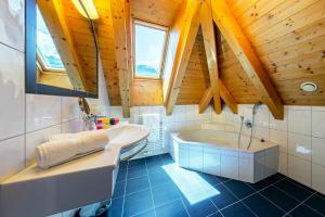 a bathroom with a wooden ceiling with a tub and a sink at Apart-Hotel Aurora Fiss in Fiss +121 photos