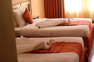 Postel nebo postele na pokoji v ubytování Astorian Grand Hotel Naivasha