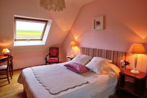 um quarto com uma cama com duas almofadas e uma janela em Chambre d'Hôtes Entre Mer et Monts em Plomodiern