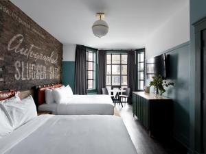 a hotel room with two beds and a table at The Chicago Hotel Collection Wrigleyville in Chicago