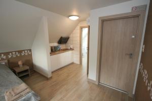 a bedroom with a sliding door and a kitchen at Noclegi Cameleon in Słupca +20 photos