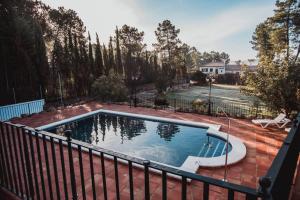 Las JarasにあるCasa del Brezo, piscina privada, cerca de Cordobaのフェンス付きのパティオのスイミングプール