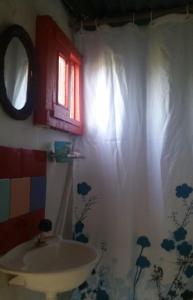 baño con lavabo y cortina de ducha en La Cañada Cabo Polonio, en Cabo Polonio