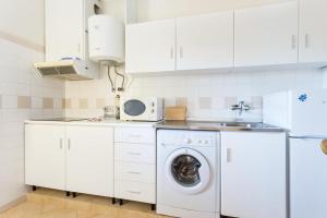 - une cuisine blanche avec un lave-linge et un évier dans l'établissement Magnoliamar 409, à Lagos
