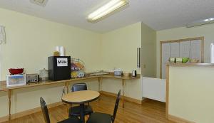 a kitchen with a table and chairs in a room at Americas Best Value Inn Saint Ignace in Saint Ignace