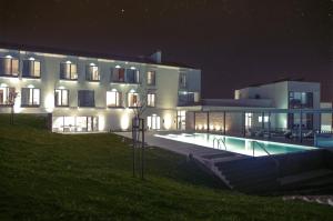 un grande edificio con piscina di notte di Real Abadia, Congress & Spa Hotel ad Alcobaça