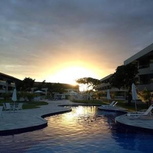 una piscina in un resort con il tramonto di Carneiros Beach Resort a Tamandaré