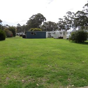 a large green field with grass and trees at Captain Cook Holiday Park in Adventure Bay